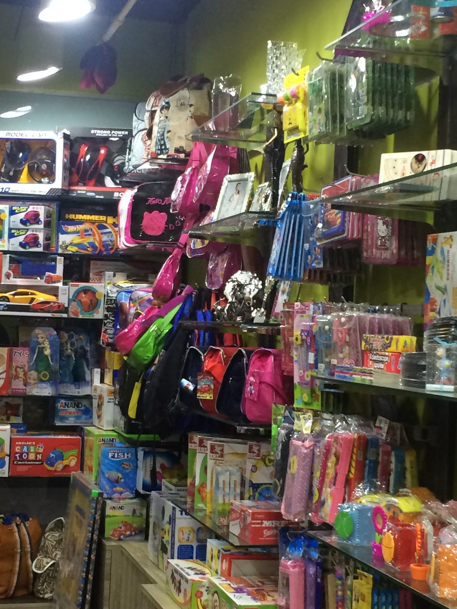 Toy store interior with shelves displaying colorful bags, backpacks, and boxed toys.