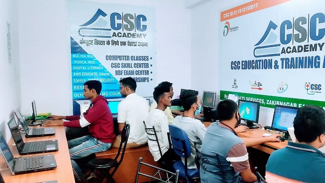 Trainer guiding a student on a computer