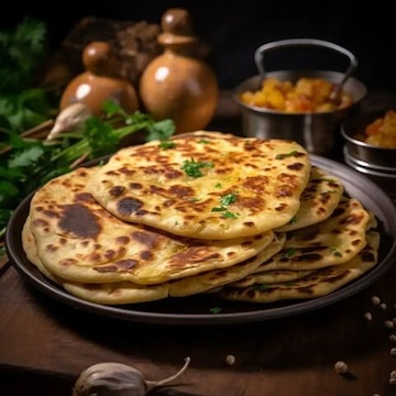 Hot parathas on a plate at a traditional street food stall